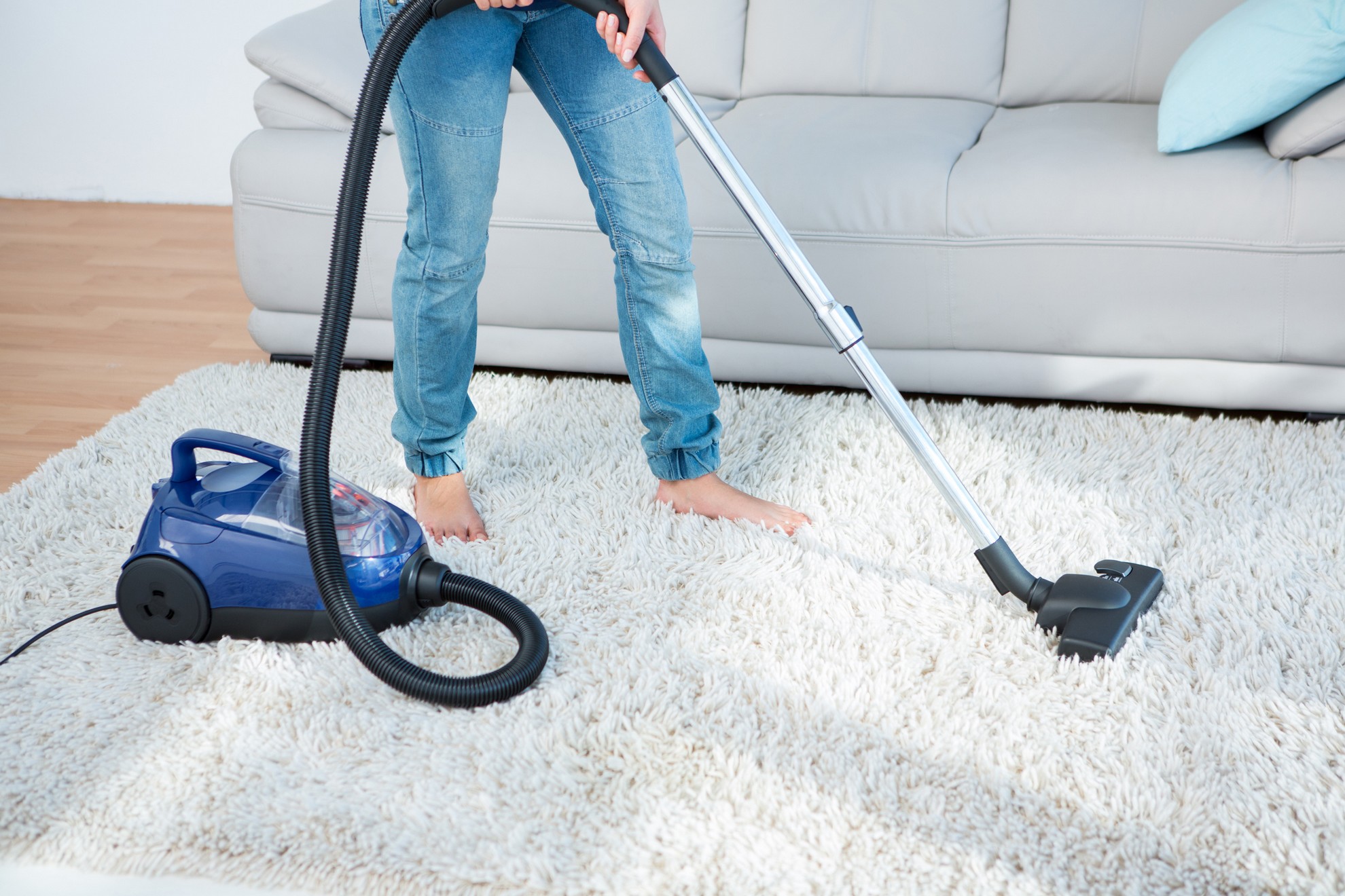 Woman using vacuum cleaner on carpet